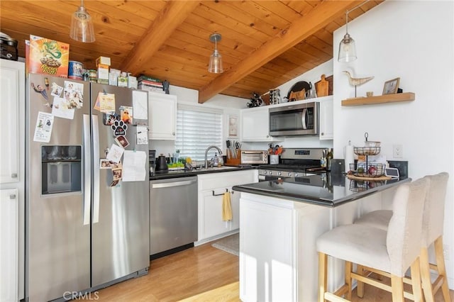 kitchen featuring pendant lighting, white cabinetry, and appliances with stainless steel finishes