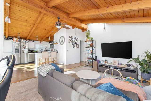 living room featuring ceiling fan, lofted ceiling with beams, and wood ceiling