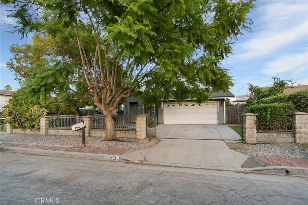 view of property hidden behind natural elements featuring a garage