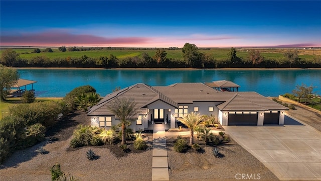 exterior space with a garage and a water view