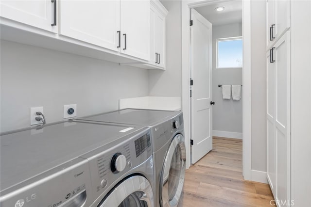 washroom featuring cabinets, separate washer and dryer, and light wood-type flooring