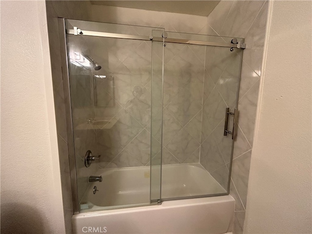 bathroom featuring bath / shower combo with glass door