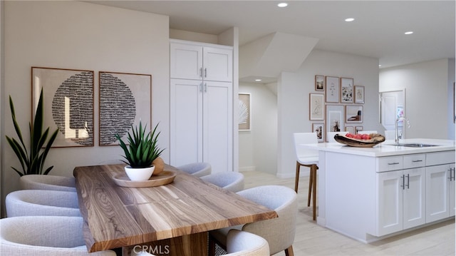 dining space with sink and light hardwood / wood-style flooring