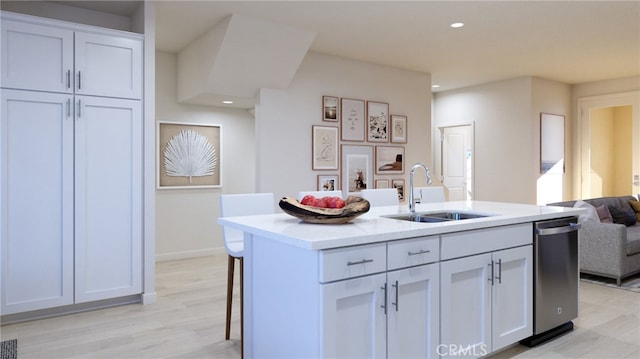 kitchen with a center island with sink, white cabinets, stainless steel dishwasher, and sink