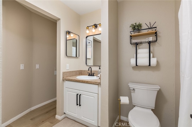 bathroom with vanity, toilet, and wood-type flooring