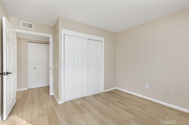 unfurnished bedroom featuring a closet and light wood-type flooring