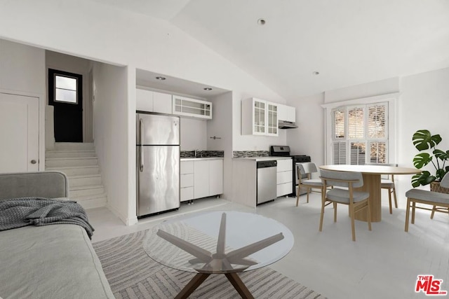 kitchen with white cabinetry, sink, stainless steel appliances, and vaulted ceiling