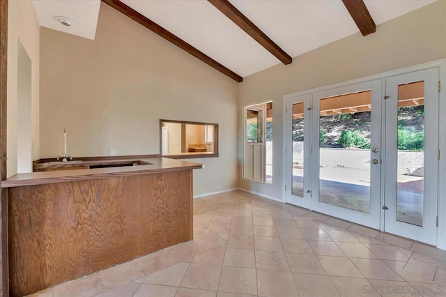 kitchen featuring high vaulted ceiling, sink, light tile patterned floors, and beamed ceiling