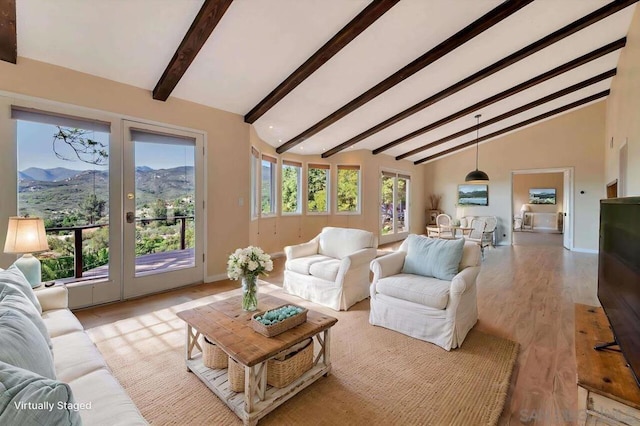 living room featuring a mountain view, light wood-type flooring, high vaulted ceiling, and beam ceiling