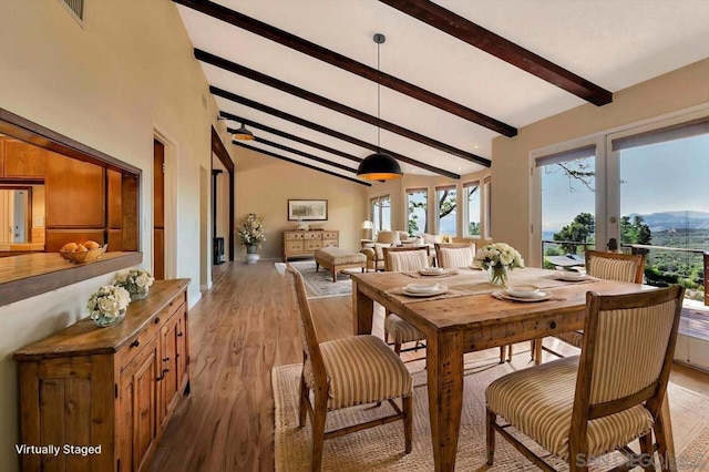 dining area with light hardwood / wood-style flooring and lofted ceiling with beams