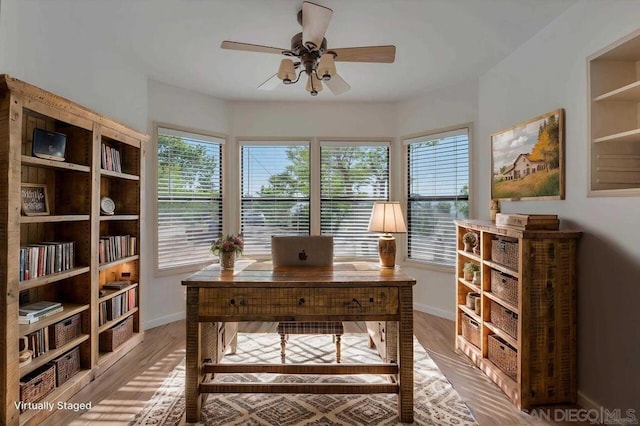 home office with a healthy amount of sunlight, hardwood / wood-style flooring, and ceiling fan