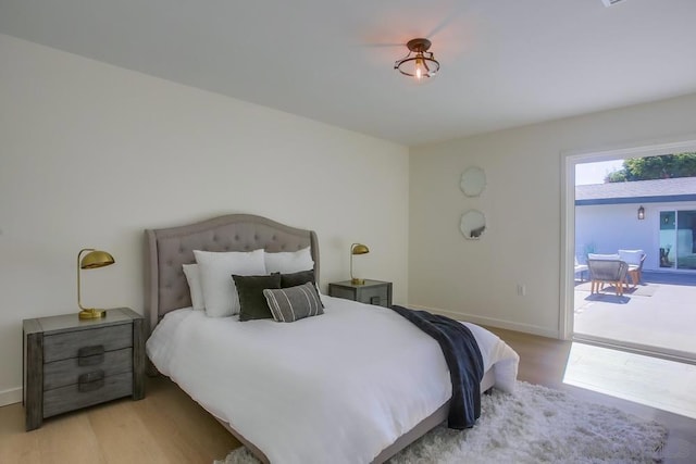 bedroom with access to outside and light wood-type flooring