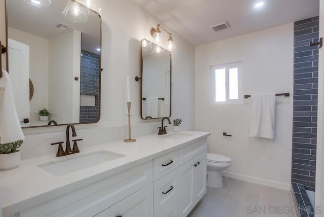 bathroom featuring toilet, vanity, and tile patterned flooring