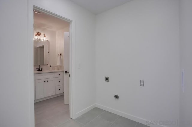 laundry area featuring light tile patterned flooring, sink, and electric dryer hookup