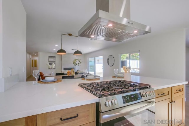 kitchen featuring pendant lighting, wall chimney exhaust hood, light brown cabinets, and high end range