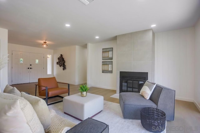 living room with light hardwood / wood-style flooring and a tile fireplace