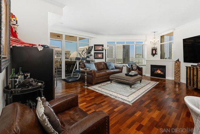 living room featuring ornamental molding, a notable chandelier, and dark hardwood / wood-style flooring