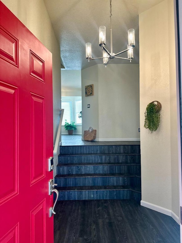 entrance foyer with wood-type flooring, a textured ceiling, and a chandelier