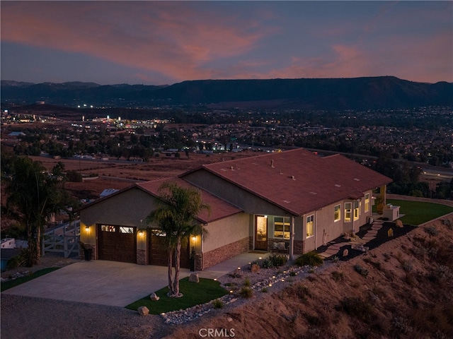 aerial view at dusk featuring a mountain view