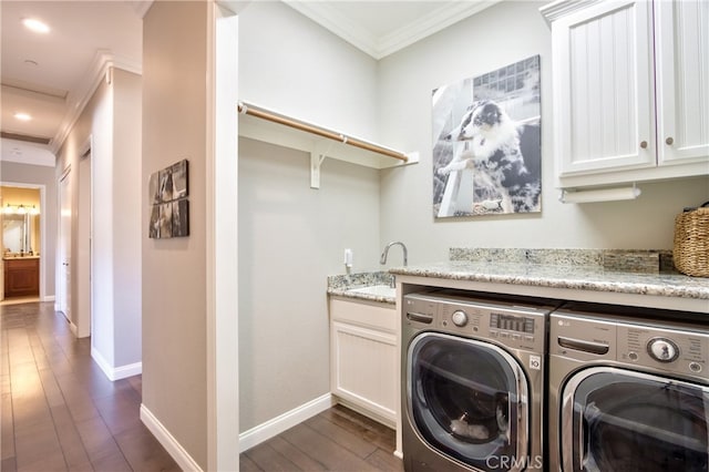 laundry room featuring independent washer and dryer, ornamental molding, cabinets, and dark hardwood / wood-style floors