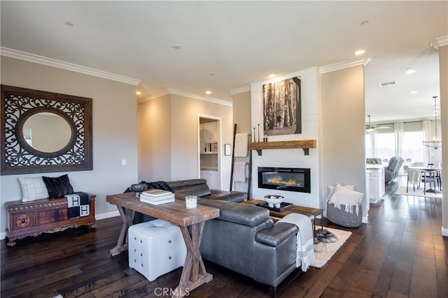 living room featuring dark wood-type flooring, crown molding, and a fireplace