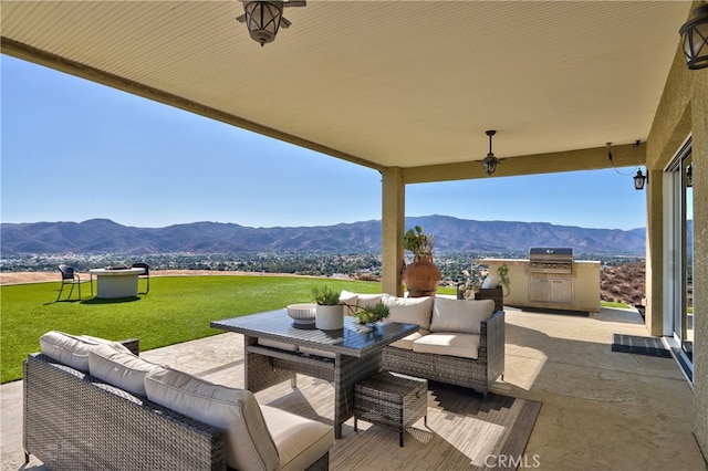 view of patio / terrace with area for grilling, a mountain view, and outdoor lounge area