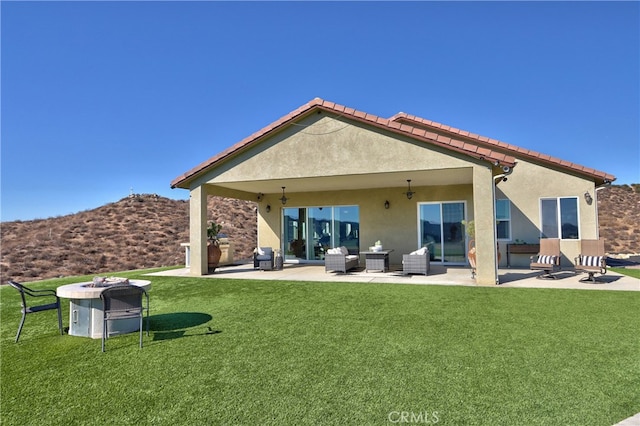 back of house with a yard, a patio area, and ceiling fan