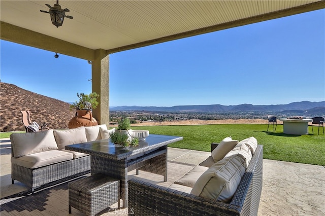 view of patio / terrace featuring ceiling fan, a mountain view, and an outdoor living space