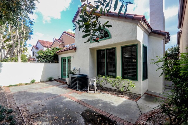 rear view of house featuring central air condition unit and a patio area