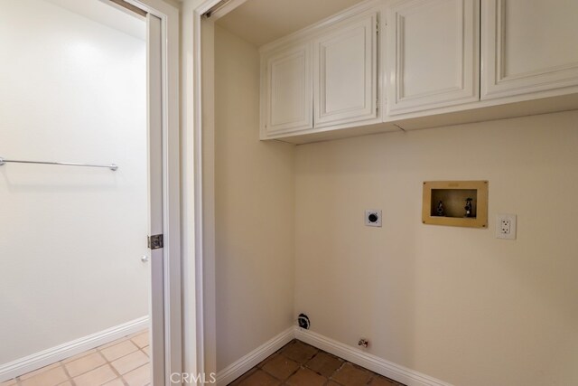 washroom with cabinets, washer hookup, light tile patterned floors, gas dryer hookup, and hookup for an electric dryer