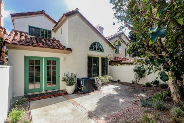 rear view of property featuring a patio area, french doors, and cooling unit