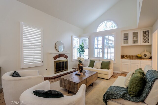 living room featuring light tile patterned flooring, a fireplace, and a healthy amount of sunlight