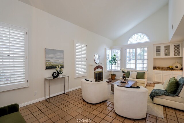 living area featuring high vaulted ceiling and light tile patterned floors