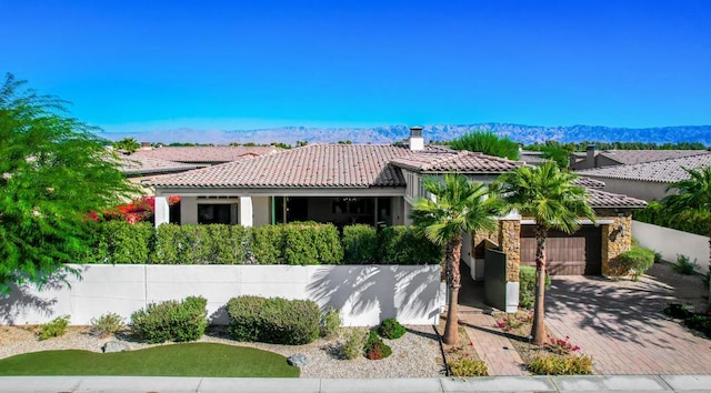 view of front of home with a garage and a mountain view