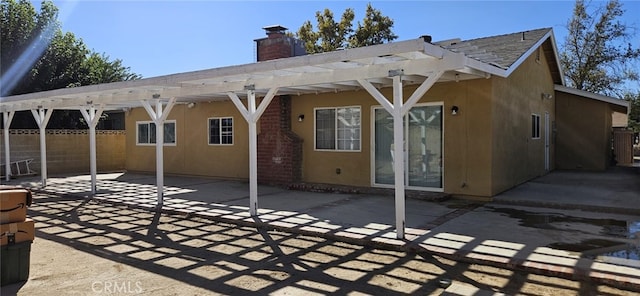 back of property featuring a pergola and a patio area