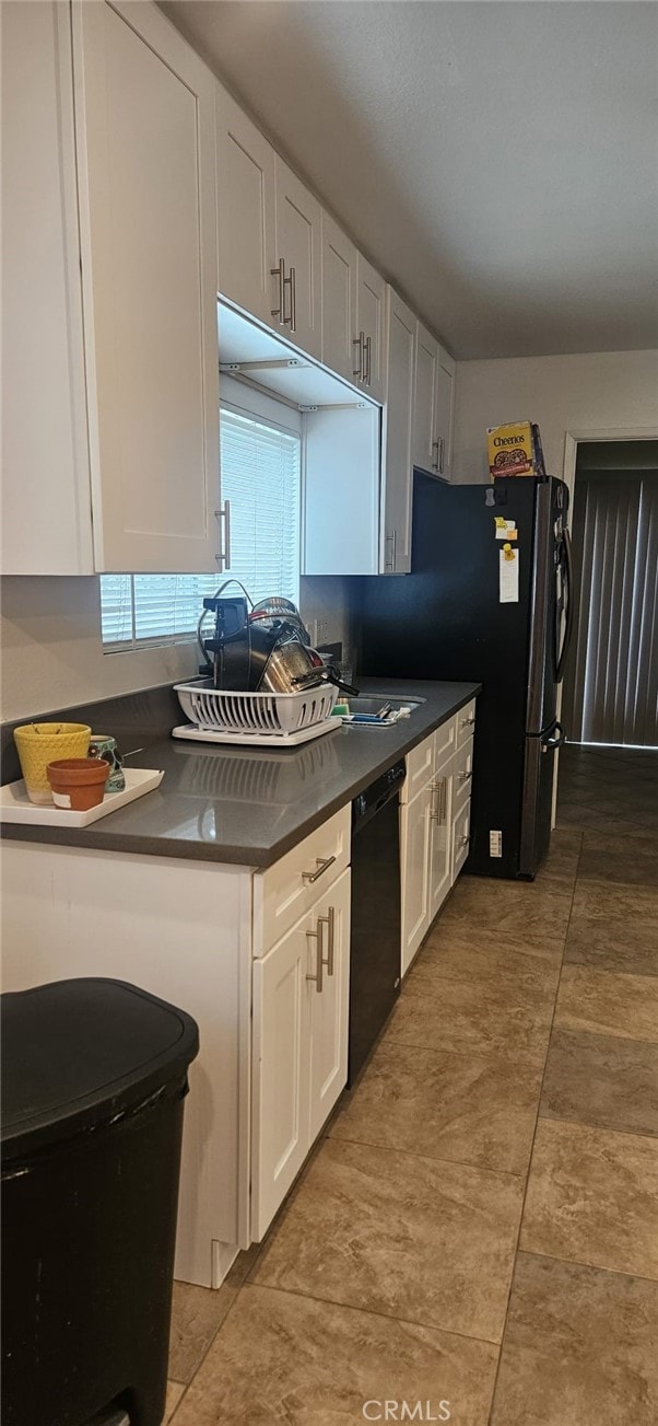 kitchen with white cabinets, tile patterned floors, and black appliances