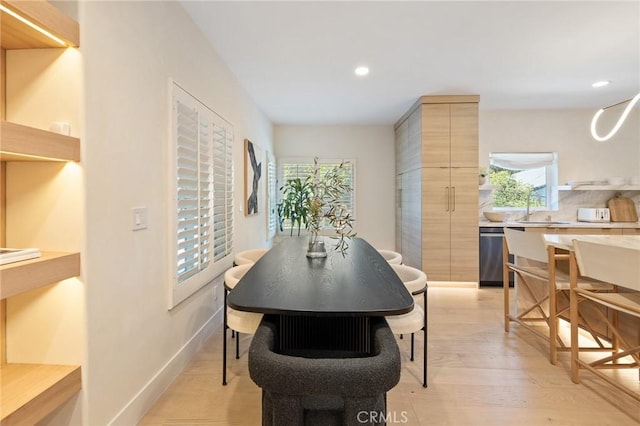 dining space with sink and light hardwood / wood-style flooring