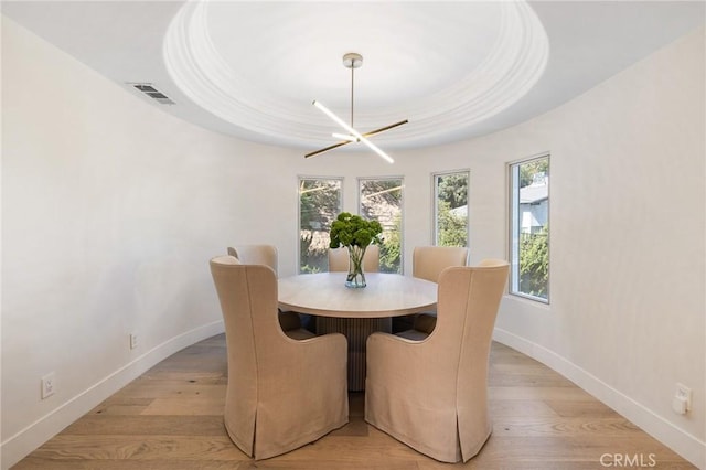 dining room with light hardwood / wood-style flooring and a notable chandelier