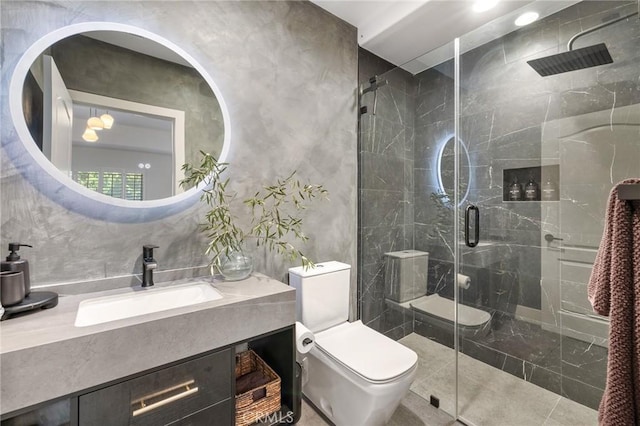 bathroom featuring a shower with door, vanity, and toilet