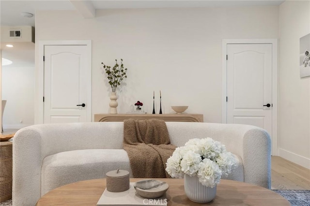 sitting room featuring beam ceiling and hardwood / wood-style floors