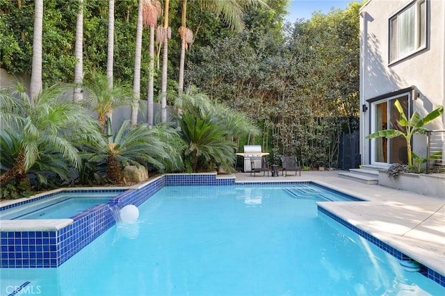 view of pool with area for grilling and a patio area