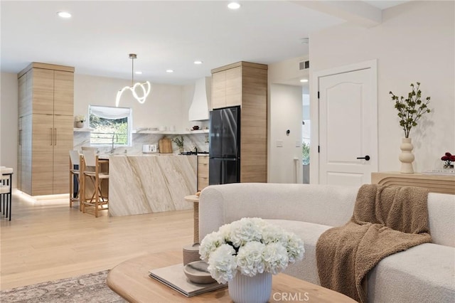 interior space with beamed ceiling and light hardwood / wood-style flooring