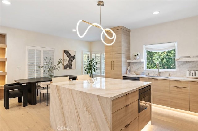 kitchen with sink, light brown cabinetry, hanging light fixtures, a center island, and built in microwave