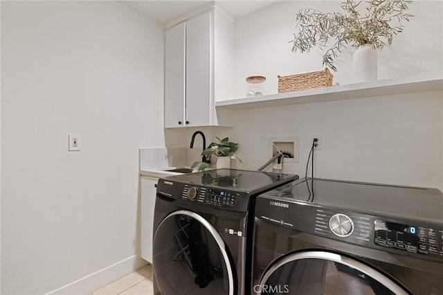 clothes washing area featuring cabinets, light tile patterned flooring, sink, and washer and clothes dryer