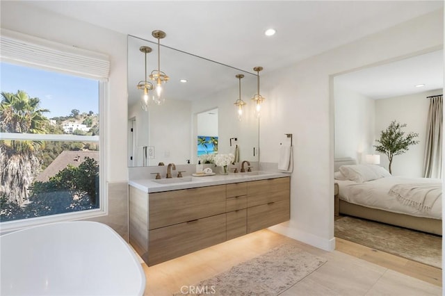 bathroom with tile patterned floors, vanity, and a washtub