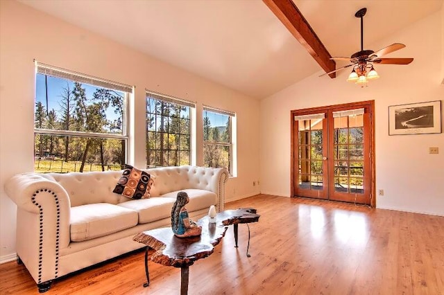 living room with light hardwood / wood-style floors, a wealth of natural light, vaulted ceiling with beams, and ceiling fan