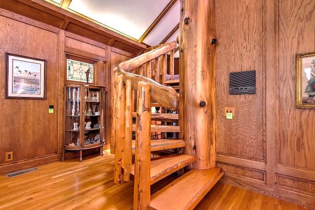 stairway with wood walls and hardwood / wood-style flooring