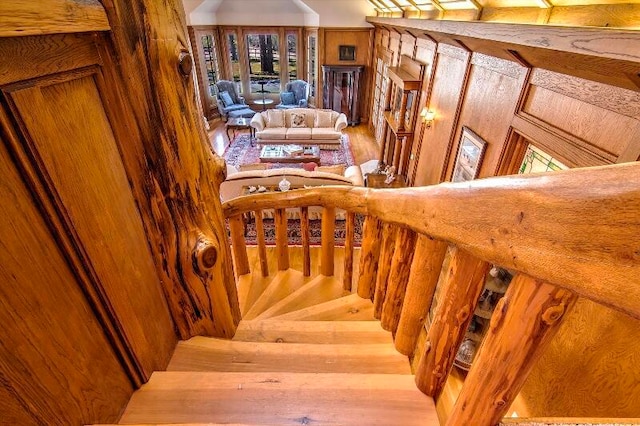 stairway featuring wooden walls and hardwood / wood-style floors