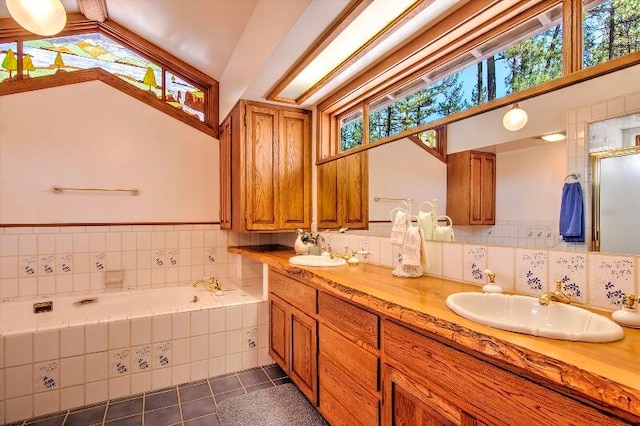 bathroom featuring vanity, lofted ceiling, a healthy amount of sunlight, and tile patterned floors