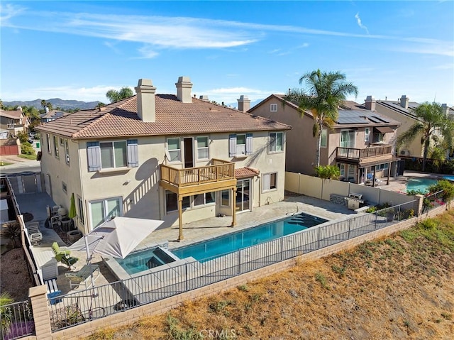 rear view of house with a balcony, a fenced in pool, and a patio area